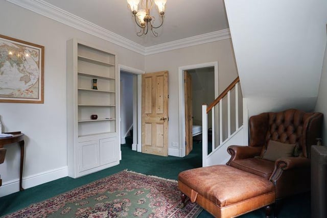 A spacious hallway with staircase leading up.