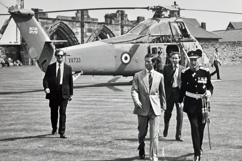 Charles arrives at Whitby Abbey grounds by Royal helicopter.