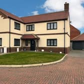 The imposing house frontage, with driveway parking and a double garage.