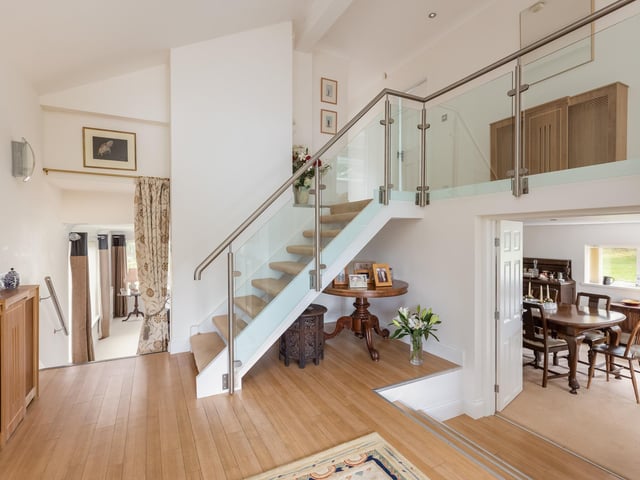 A staircase with glass balustrade leads from the hallway to the part-gallery landing.