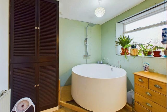 A large round bath is a bathroom feature.