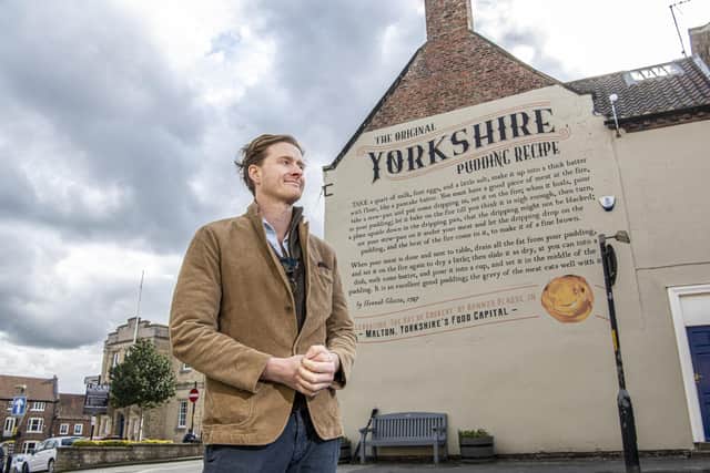 Tom Naylor-Leyland, organiser of the Malton Food Festival, in front of the large mural of a Yorkshire pudding recipe dating from the 18th century which was created a couple of years ago