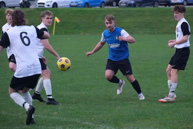 Newby, blue kit, on the attack against Scalby. Photo by Richard Ponter