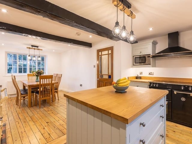 The beamed dining kitchen includes cabinetry by Hovingham Interiors.