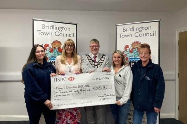 Councillor John Arthur presents a cheque to the Homeless Hub and the Hinge Centre. Photo courtesy of Bridlington Town Council.