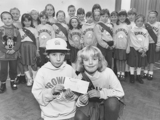 In November 1995, Brownies Becky Shone, left, and Samantha Wilton, are pictured with the cheque for £53.50 which was raised for the RSPCA. Looking on are the other Brownies who helped with the fundraising.