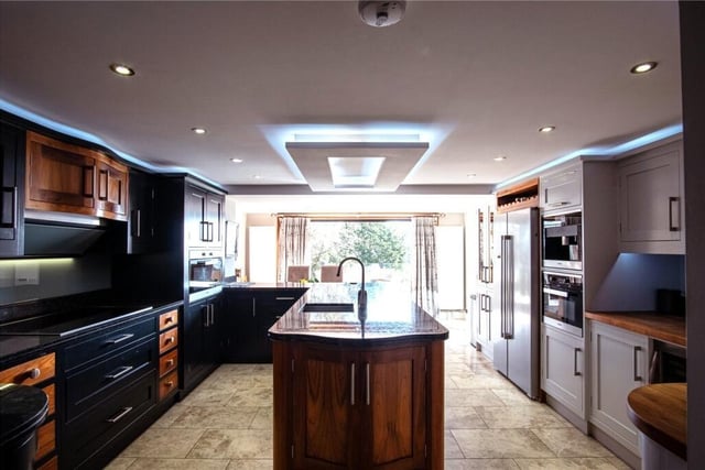 A high spec kitchen with central island unit and granite work surfaces.