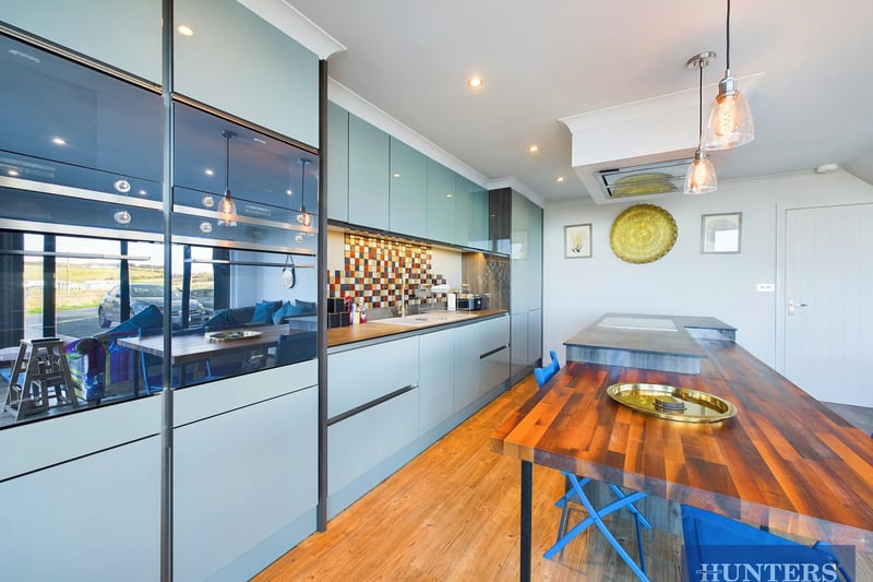 A sleek and modern breakfast kitchen has integrated appliances.