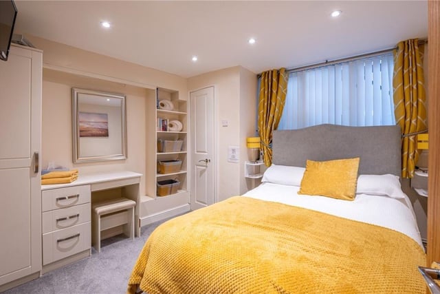 A double bedroom with fitted furniture and ceiling spotlights.