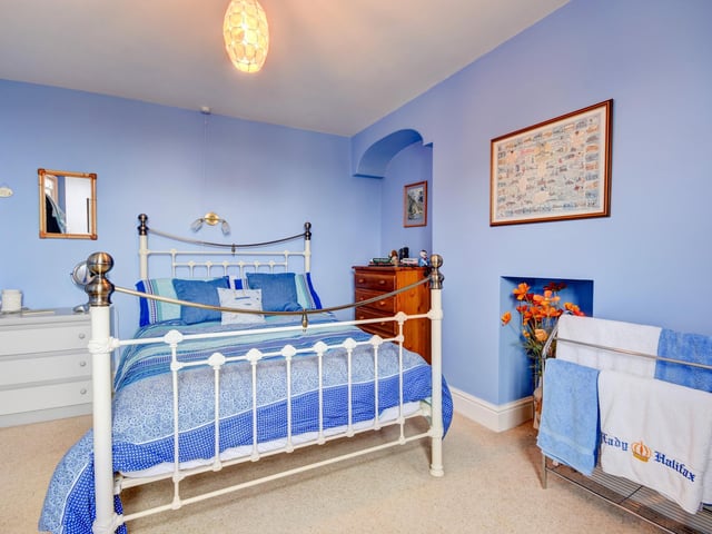 A bedroom in blue, with decorative niche features.