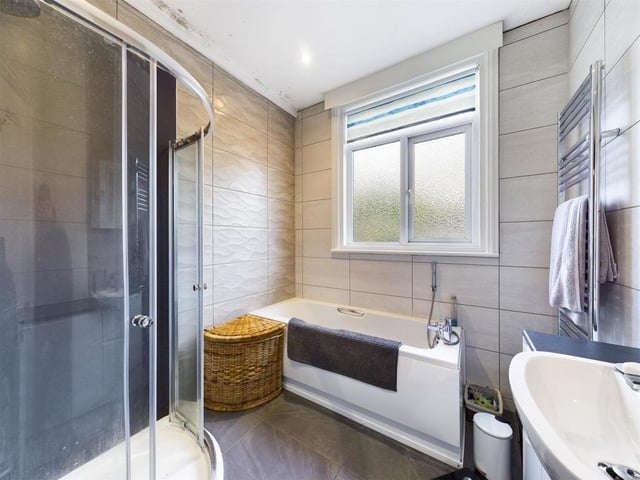A stylish family bathroom with curved shower cubicle.