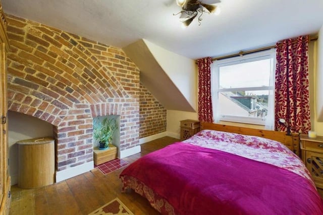 A bedroom with feature exposed brick wall.
