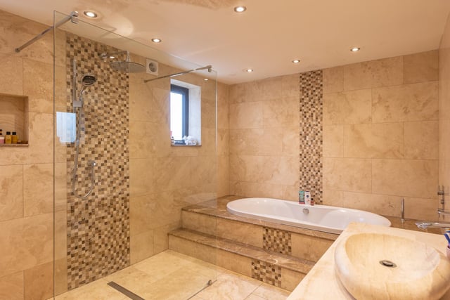 This swish, fully tiled bathroom is one of three within the house.