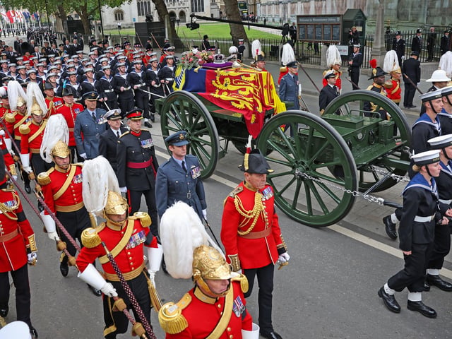 The State Gun Carriage carries the coffin of Queen Elizabeth II, draped in the Royal Standard with the Imperial State Crown and the Sovereign's orb and sceptre, as it makes its way for the State Funeral at Westminster Abbey. (Photo by Marc Aspland / POOL / AFP) (Photo by MARC ASPLAND/POOL/AFP via Getty Images)