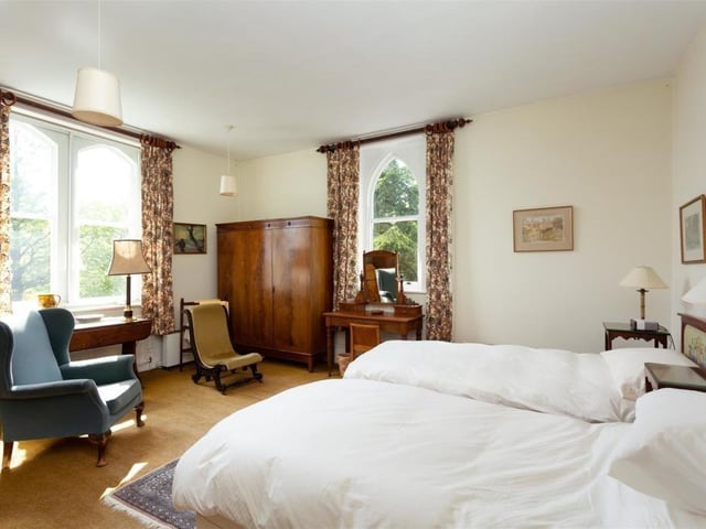 This spacious double bedroom has a feature arched window.