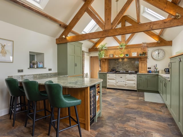 A kitchen with bespoke units and polished granite worktops.