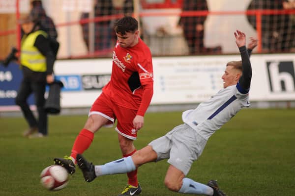 Brid Town's Matty Dixon clearing the ball from a Dunston attacker.