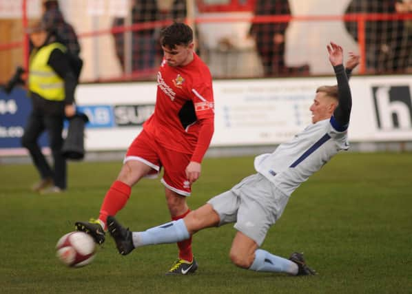 Brid Town's Matty Dixon clearing the ball from a Dunston attacker.