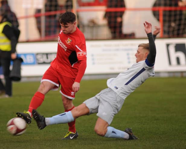 Brid Town's Matty Dixon clearing the ball from a Dunston attacker.