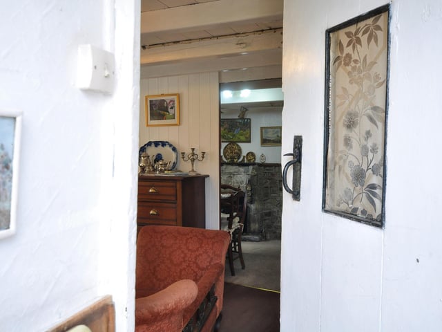 A latched cottage door opens through to the ground floor rooms.