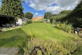 The large lawned garden with established borders has a summer house, a workshop and a garden room.