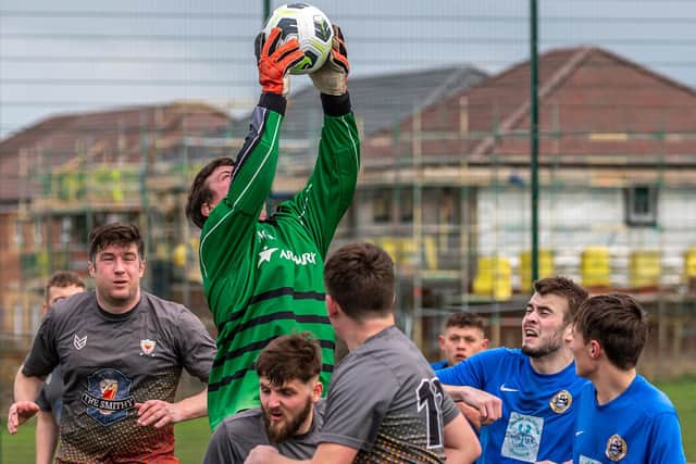 The Amotherby & Swinton Reserves keeper claims the ball in a crowded penalty area.