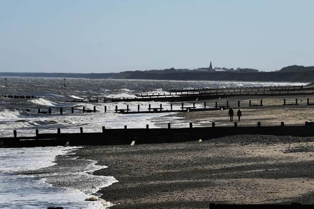 A couple walk down the beach at Hornsea. (Pic credit: Jonathan Gawthorpe)