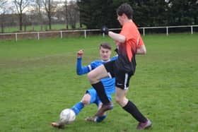 The visitors Heslerton U16s slide into a challenge against North Duffield.