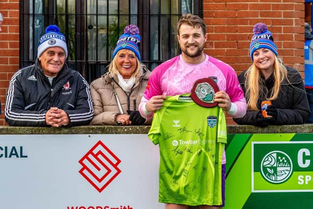 Keeper Shane Bland with a signed shirt and shield to commemorate his record appearances for Whitby Town before the Leek game. Photo by Brian Murfield