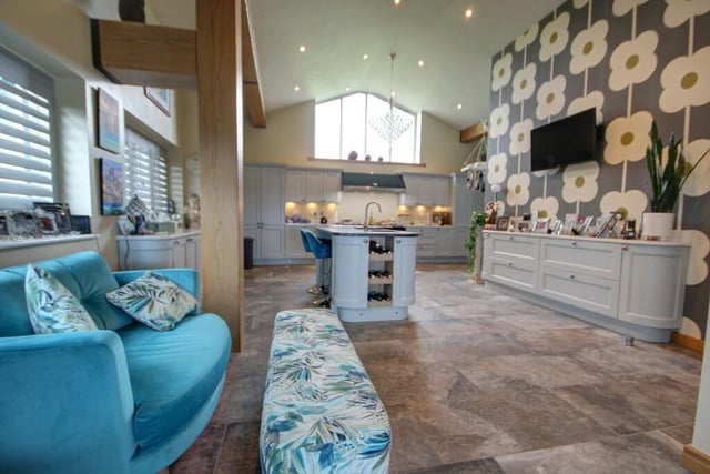 A wider view of the spacious kitchen, that flows to a breakfast room and family space.