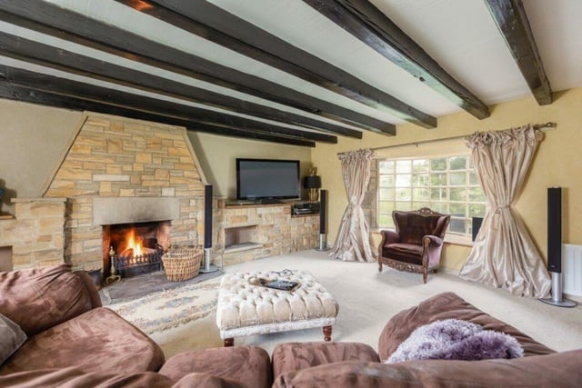 The spacious lounge, with a feature fireplace and plenty of natural light from the large window.