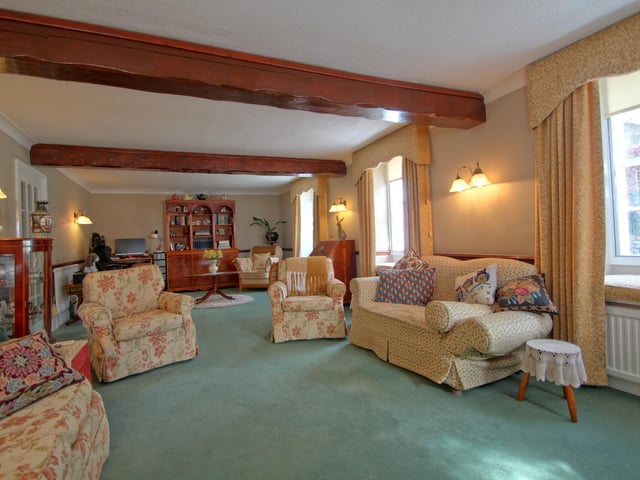 The spacious beamed lounge has a feature fireplace, with room for a dining or office area.