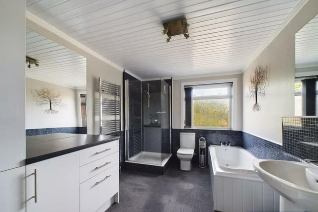 The well equipped and spacious modern bathroom has both bath and shower.