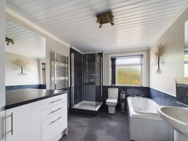 The well equipped and spacious modern bathroom has both bath and shower.