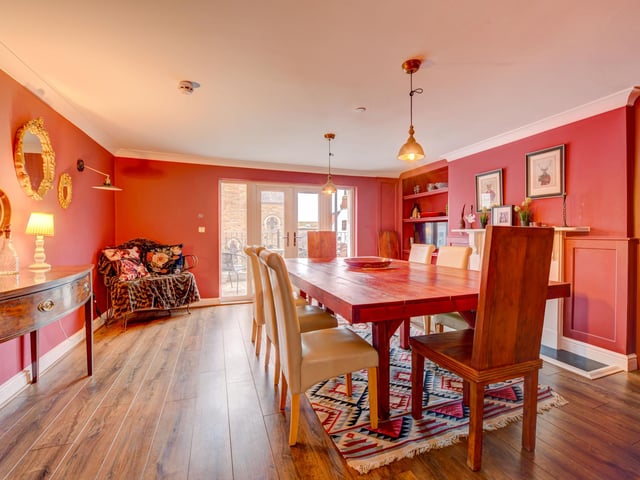 The dining room is linked to the kitchen and has double doors that lead out to a spacious balcony.