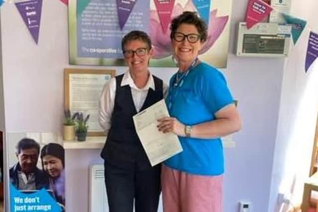 Samantha Buckle from WHISH receives a cheque for £250 from Whitby Co-op Funeralcare branch funeral arranger, Susan Hodgson.