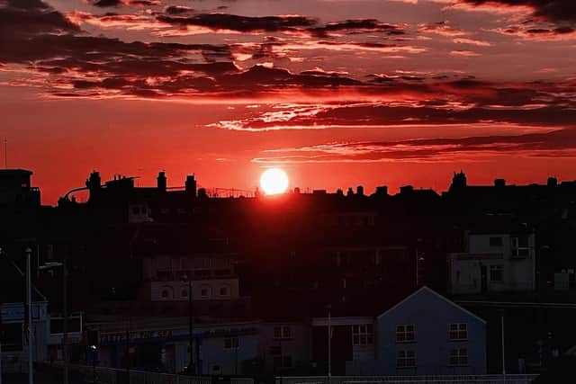 A dark red sunrise, by Aled Jones.
