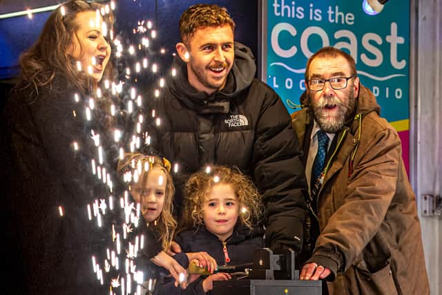 The Christmas lights switch-on in Whitby with Judith Aconley, 5 and Whitby Town skipper Dan Rowe.
picture: Brian Murfield.