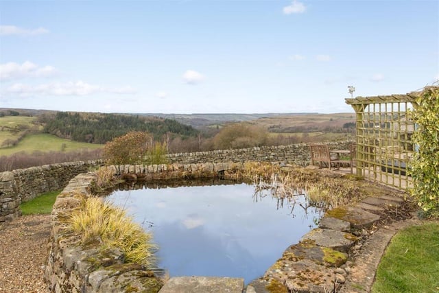 The extensive garden includes a pond.