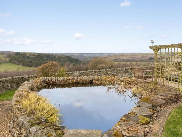 The extensive garden includes a pond.