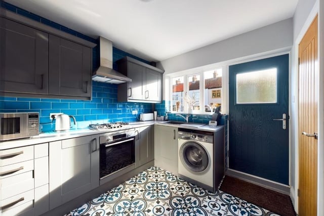 The kitchen has a range of fitted units with rolled top work surfaces, and an integrated oven and hob.