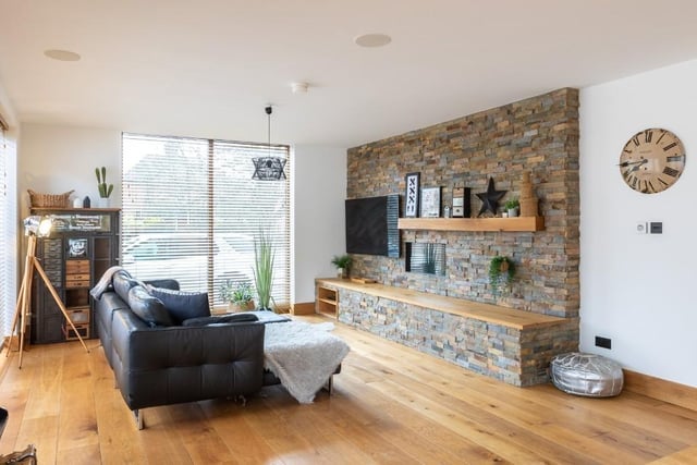 A sitting room with feature wall and inbuilt shelf.