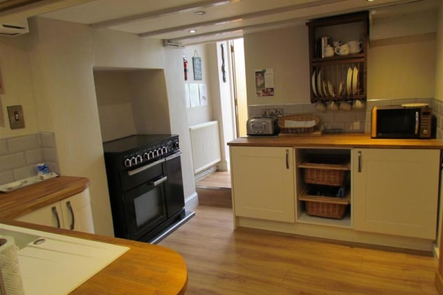 The beamed kitchen includes a range oven and hob.