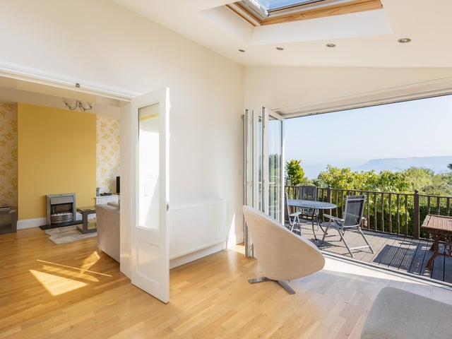 Bi-fold doors open up the garden room to a decked area outside.