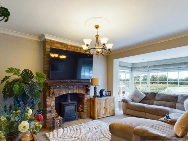The bay-fronted lounge with brick fireplace feature and log-burner.
