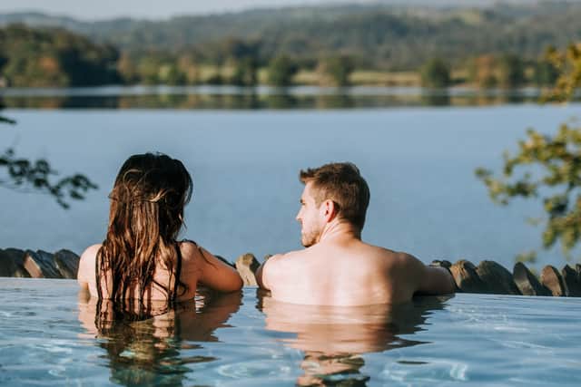 A couple pictured relaxing in Low Wood Bay's Fellside Infinity Pool, looking out onto Lake Windermere.