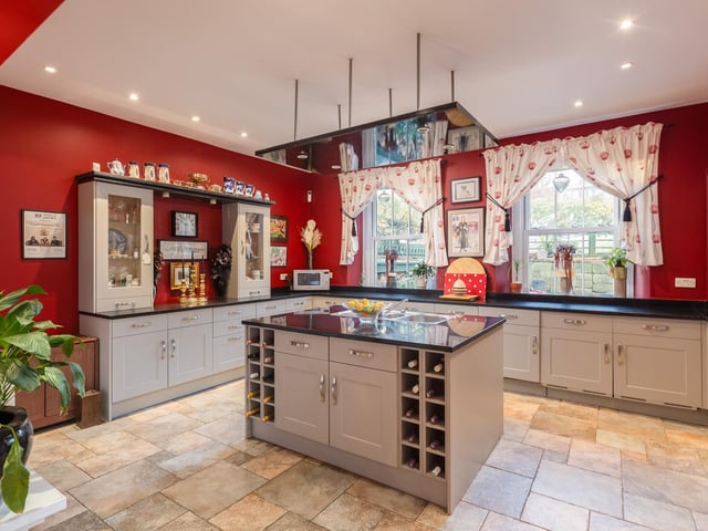 The main kitchen with a central island and granite worktops, has original recessed cupboards.