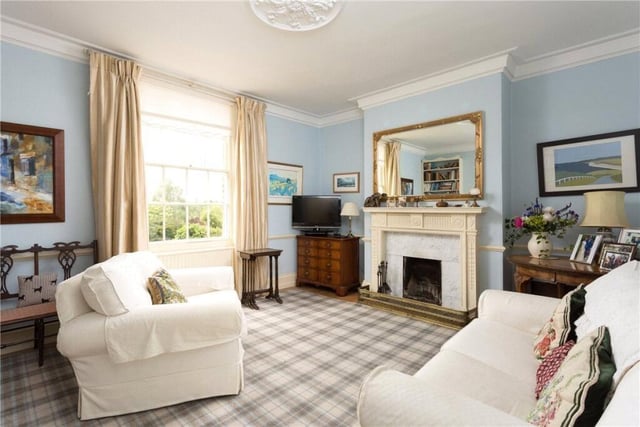 A bright reception room with a feature fireplace.