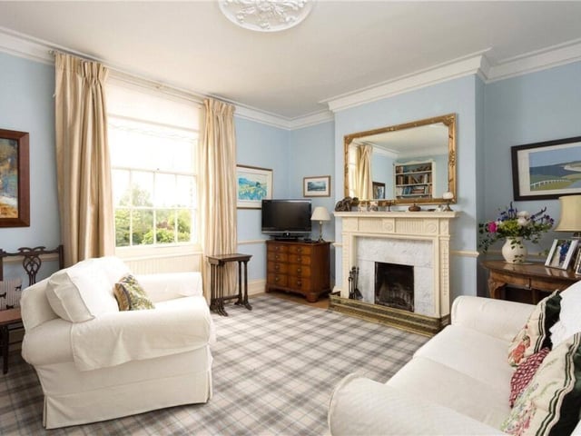 A bright reception room with a feature fireplace.