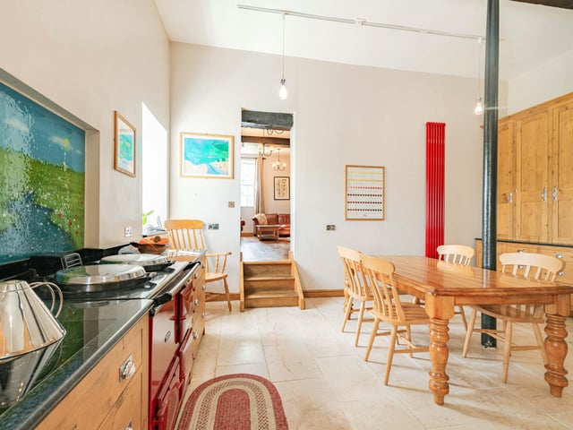 The kitchen with breakfast room has an Aga, bespoke pippy oak cabinets and black granite worktops.